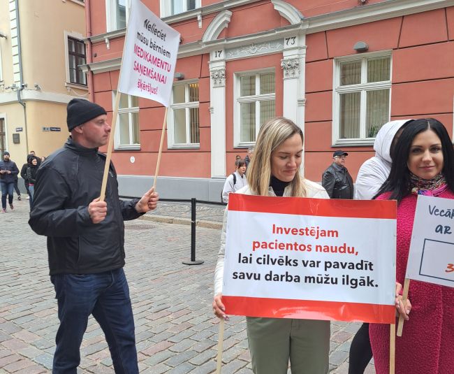 Cistiskās fibrozes pacientu vecāki pulcējas pie Saeimas