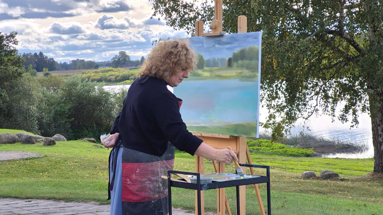 Ilze Griezāne izstādes atklāšanā parāda gleznu radīšanas procesu